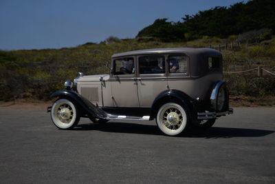 Vintage car parked on road against sky