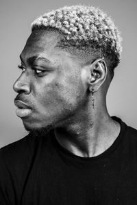 Close-up of young man looking away against white background