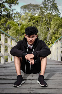 Full length portrait of young man against plants