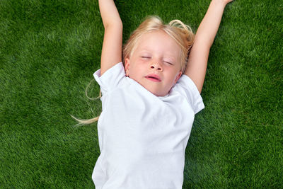 High angle view of boy playing with ball on grassy field