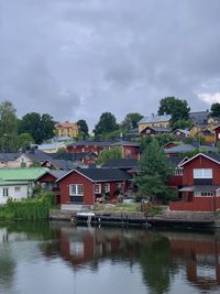 Houses by lake against sky