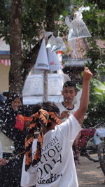 Rear view of people holding umbrella