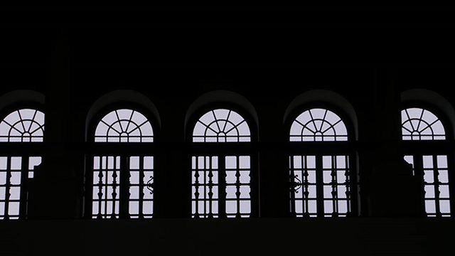 indoors, window, architecture, built structure, arch, dark, low angle view, no people, copy space, day, glass - material, religion, church, house, old, building, side by side, pattern, place of worship