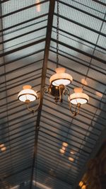 Low angle view of illuminated pendant lights hanging on ceiling