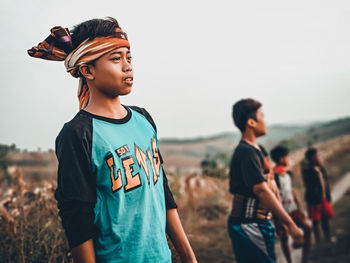 Young couple looking away against sky