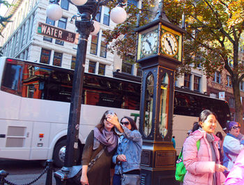 Full length of woman photographing with mobile phone in city