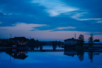 Reflection of building in lake against sky at dusk