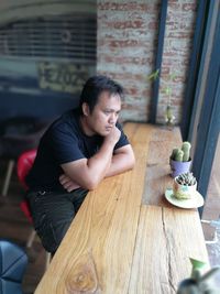 Serious man sitting at table in cafe