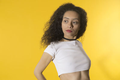 Portrait of woman against yellow background