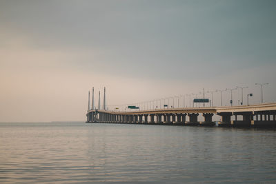 Pier over sea against sky during sunset