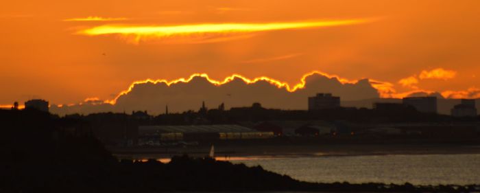 Scenic view of river against sky during sunset