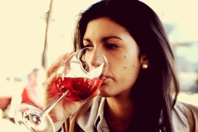 Close-up of young woman drinking red wine