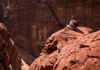 Full length of man sitting on rock