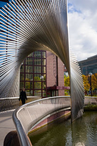 Bridge over canal in city against sky
