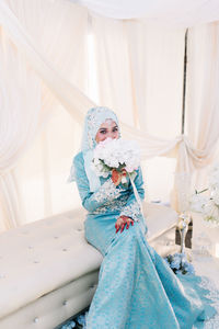 Bride wearing blue wedding dress sitting at stage