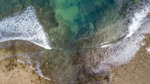 High angle view of waves splashing on beach