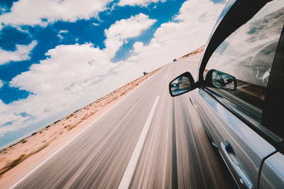 Car moving on road against sky