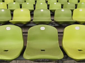 Full frame shot of empty green chairs at stadium