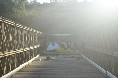 Footbridge over mountain against sky