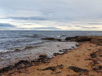 Scenic view of beach against sky during sunset