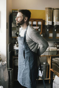 Side view of owner wearing apron in food store