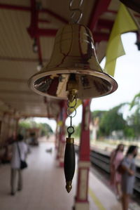 Close-up of electric lamp hanging on ceiling in city