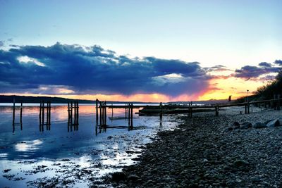 Pier on sea at sunset