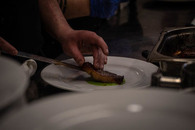 Cropped hand of man preparing food in kitchen