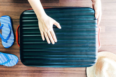 Cropped hands of woman holding suitcase