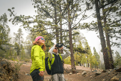 Woman standing with son at forest