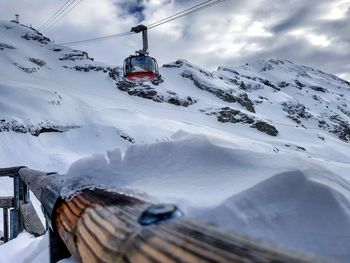 Overhead cable car against snowcapped mountains during winter