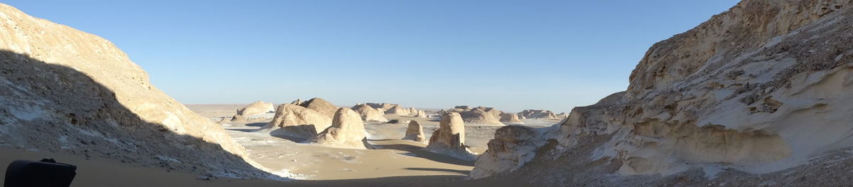 Panoramic view of rock formations against clear sky