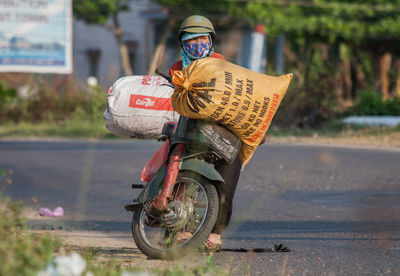 Rear view of man with bicycle on road