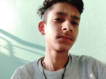 Close-up portrait of young man against wall