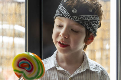 Portrait of boy looking to lollipop 