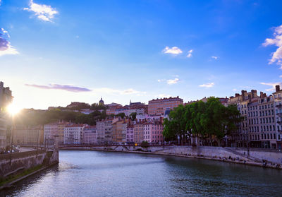 Bridge over river against buildings in city