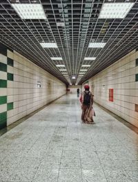 Rear view of woman walking in subway