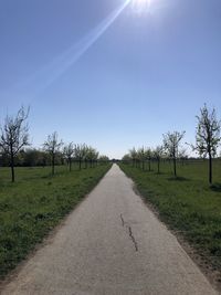 Road amidst field against sky