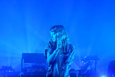 Young woman photographing at music concert