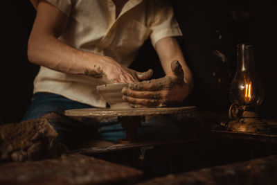 Man in pottery workshop makes plate of clay, an authentic atmosphere, yellow lamp, lifestyle, 