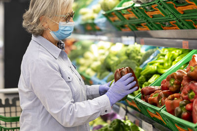 Side view of senior woman wearing mask shopping at store