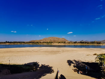 Scenic view of beach against blue sky