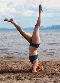 Low section of person walking on beach against sky