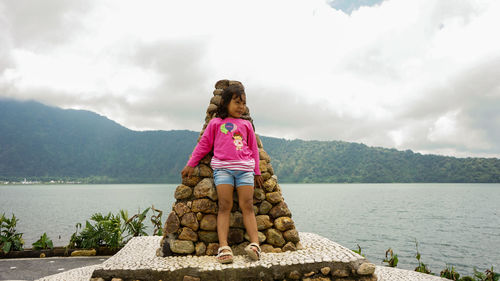 Woman looking at lake against mountain