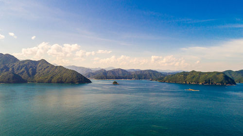 Scenic view of sea and mountains against sky