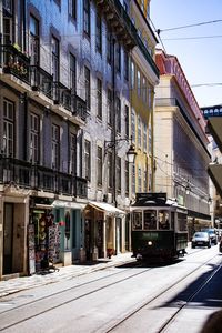 Cars on street in city against sky