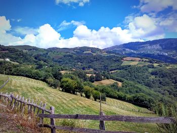 Scenic view of field against cloudy sky