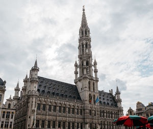 Low angle view of clock tower against cloudy sky