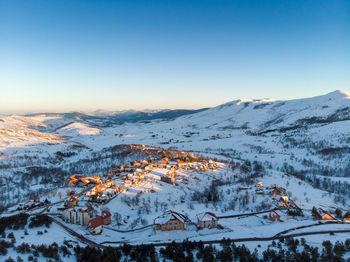 Aerial view of snowcapped mountains against clear sky