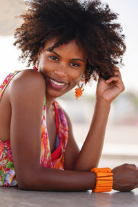 Portrait of a young black woman by the beach wearing colorful clothing